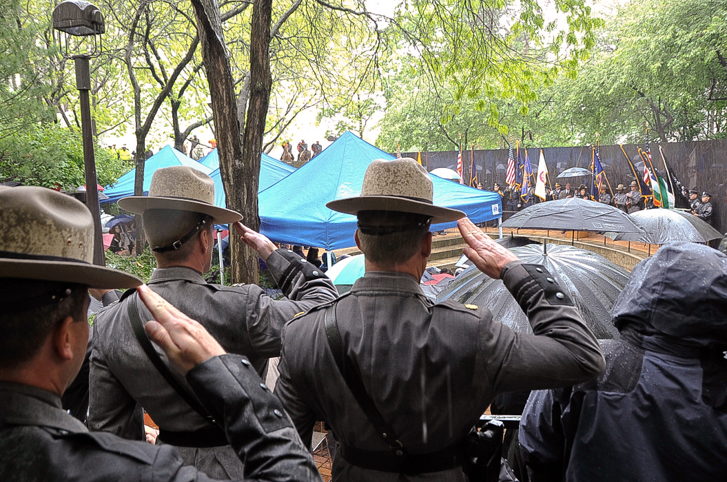 New York State Troopers salute as the colors are presented at the Police Officers' Memorial Remembrance Ceremony.