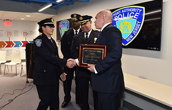 DCJS Executive Deputy Commissioner Michael C. Green congratulates Lt. Miriam Rubio as, from left to right, Port Authority Police Department Deputy Chief Michael Brown and Chief of Operations Emilio Gonzalez and look on