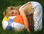 Child leaning on beach ball